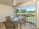 The lanai offers lovely golf course views, complemented by a table with four chairs and a ceiling fan at 421 Cerromar Ter # 471, Venice, FL 34293