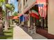Venice Mall entrance featuring international flags, comfortable benches, and lush landscaping, inviting shopping experience at 421 Cerromar Ter # 471, Venice, FL 34293