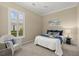 Comfortable bedroom featuring a sunny window and white wicker chair at 427 Autumn Chase Dr, Venice, FL 34292