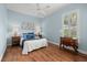 Comfortable bedroom with light blue walls, wood flooring, ceiling fan, and plenty of natural light at 427 Autumn Chase Dr, Venice, FL 34292