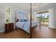 Well-lit primary bedroom featuring a four-poster bed and screened outdoor view at 427 Autumn Chase Dr, Venice, FL 34292