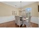Dining room boasts decorative wainscoting, elegant chandelier, and a view of the shutters over the window at 427 Autumn Chase Dr, Venice, FL 34292