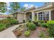 Inviting front entrance with a blue door, arched entryway, and well-maintained landscaping at 427 Autumn Chase Dr, Venice, FL 34292