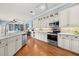 Modern kitchen featuring white cabinets, stainless steel appliances, and backsplash with access to living areas at 427 Autumn Chase Dr, Venice, FL 34292