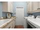 Convenient laundry room featuring modern washer and dryer, sink, granite counters, and plenty of storage at 427 Autumn Chase Dr, Venice, FL 34292