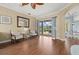 Well-lit living room featuring hardwood floors, comfortable seating, and sliding glass doors to outdoor patio at 427 Autumn Chase Dr, Venice, FL 34292