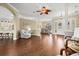 Spacious living room featuring wood floors, columns, and an open floor plan into the kitchen and dining area at 427 Autumn Chase Dr, Venice, FL 34292