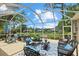 Enclosed patio with a variety of seating options and an expansive view of the landscaped backyard at 427 Autumn Chase Dr, Venice, FL 34292