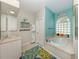 Bright bathroom with a soaking tub, tiled floor, and beach-themed decorations at 463 Park Trace Blvd, Osprey, FL 34229