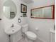 Half bath with pedestal sink, round mirror and tiled floors at 463 Park Trace Blvd, Osprey, FL 34229