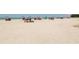 Open sandy beach dotted with colorful umbrellas and beachgoers enjoying a relaxing day by the sea at 463 Park Trace Blvd, Osprey, FL 34229