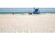Expansive beach with soft, white sand, a lifeguard tower, and people enjoying the sun and surf at 463 Park Trace Blvd, Osprey, FL 34229