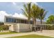 Modern Siesta Beach building with architectural design, surrounded by palm trees and vibrant green lawn at 463 Park Trace Blvd, Osprey, FL 34229