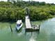 Picturesque waterfront dock with a boat, providing convenient access to the water and scenic views at 463 Park Trace Blvd, Osprey, FL 34229