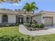 Inviting home entrance features a well-maintained lawn, lush garden beds and covered front entryway at 463 Park Trace Blvd, Osprey, FL 34229