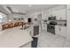 Modern kitchen featuring stainless steel appliances and a breakfast bar that opens to the living area at 463 Park Trace Blvd, Osprey, FL 34229