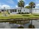 Waterfront home with lush lawn, palm trees and an enclosed porch at 485 Schooner St, North Port, FL 34287