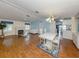 Open-concept living room with fireplace and dining area featuring a white table set and elegant chandelier at 485 Schooner St, North Port, FL 34287