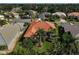 Charming home with a terracotta roof surrounded by a lush green lawn and tropical landscaping with towering palm trees at 4912 Bella Terra Dr, Venice, FL 34293