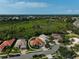 Aerial view of a terracotta-roofed home in a residential area near a green space and a highway, showcasing community living at 4912 Bella Terra Dr, Venice, FL 34293