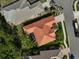 Aerial view of terracotta-roofed home showing well-manicured landscaping, paver driveway, and screen-enclosed patio at 4912 Bella Terra Dr, Venice, FL 34293