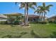 Lush backyard featuring a well-manicured lawn and mature palm trees at 4912 Bella Terra Dr, Venice, FL 34293