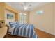 Comfortable bedroom with a built-in desk, bed with blue striped comforter, and view to the window at 4912 Bella Terra Dr, Venice, FL 34293