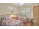 Bedroom with twin beds, wood floors, and natural light from the window with white shutters at 4912 Bella Terra Dr, Venice, FL 34293