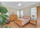 Cozy bedroom with wood floors, a tray ceiling, a ceiling fan, and neutral-toned walls at 4912 Bella Terra Dr, Venice, FL 34293