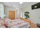 Cozy bedroom with wood floors and neutral-toned walls, featuring a plant, a TV, and a ceiling fan at 4912 Bella Terra Dr, Venice, FL 34293