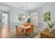 Cozy dining area with modern chandelier, window with shutters, seating for four, and tile flooring at 4912 Bella Terra Dr, Venice, FL 34293