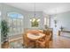 Charming dining area with table seating four, modern chandelier, natural light, and tile flooring at 4912 Bella Terra Dr, Venice, FL 34293