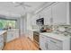 Bright kitchen featuring white cabinets, stainless steel appliances, mosaic backsplash, and tile flooring at 4912 Bella Terra Dr, Venice, FL 34293