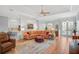 Spacious living room featuring a large sectional sofa, tile flooring, and views into kitchen and dining area at 4912 Bella Terra Dr, Venice, FL 34293