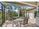 Screened patio with an outdoor dining set overlooking the lush backyard at 4912 Bella Terra Dr, Venice, FL 34293