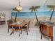 Charming dining area with a beach mural, wooden table set, chandelier, and white tile floors at 528 W Venice Ave # 1, Venice, FL 34285