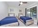 Cozy bedroom with two beds, rustic wood furniture, modern ceiling fan and art at 5674 Palmer Circle Dr # 203, Bradenton, FL 34211
