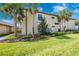 Exterior view of well-maintained home with lush lawn, manicured landscaping and palm trees at 5674 Palmer Circle Dr # 203, Bradenton, FL 34211