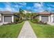 Beautiful condo exterior with lush landscaping, paver path, and private garages on a sunny day at 5674 Palmer Circle Dr # 203, Bradenton, FL 34211