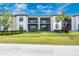 A condo community building with well-manicured lawn and landscaping and screened-in patios at 5674 Palmer Circle Dr # 203, Bradenton, FL 34211