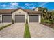Charming villa exterior showcasing a paver driveway leading to a two-car garage at 5674 Palmer Circle Dr # 203, Bradenton, FL 34211