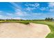 Beautiful golf course view with a sand trap and green grass under a bright blue sky at 5674 Palmer Circle Dr # 203, Bradenton, FL 34211
