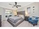 Beautiful main bedroom featuring a cozy chair and modern ceiling fan at 5674 Palmer Circle Dr # 203, Bradenton, FL 34211