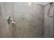This bathroom features a neutral colored tile shower, chrome fixtures, and a hand-held shower head at 5674 Palmer Circle Dr # 203, Bradenton, FL 34211