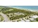 Aerial view of the beach featuring sandy shoreline, clear turquoise waters, and palm trees at 57 Sandstone Cir, Venice, FL 34293