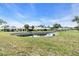 Beautiful backyard view with a pond surrounded by lush green grass and mature trees in a quiet neighborhood at 57 Sandstone Cir, Venice, FL 34293