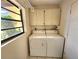 Bright laundry room with washer, dryer, and white cabinets at 57 Sandstone Cir, Venice, FL 34293