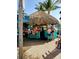 Lively outdoor bar with a thatched roof and seated patrons at 57 Sandstone Cir, Venice, FL 34293