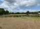 Expansive backyard featuring lush lawn, mature trees, and a peaceful pond at 5760 Howard Creek Rd, Sarasota, FL 34241