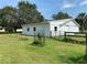 Well-maintained outbuilding with a metal roof, fencing, and mature landscaping at 5760 Howard Creek Rd, Sarasota, FL 34241